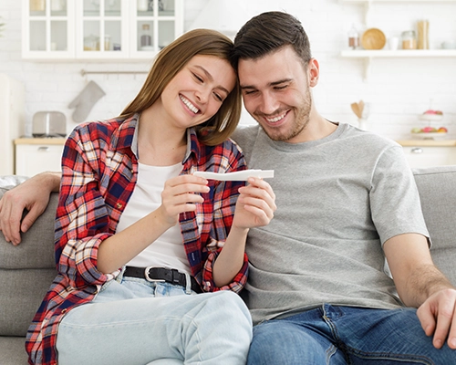 young excited couple look at positive result